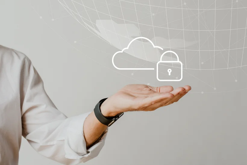An open hand holding a floating, stylized cloud and padlock icon, representing cloud security. In the background, hinted global networks or data connections are visible, all against a light gray background.